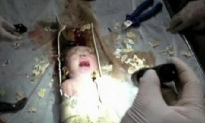 Still image of an abandoned newborn baby boy seen in a sewage pipe following his rescue in Jinhua city