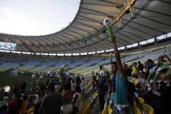 Soccer fans cheer during the re-opening of the newly renovated Maracana Stadium in Rio de Janeiro
