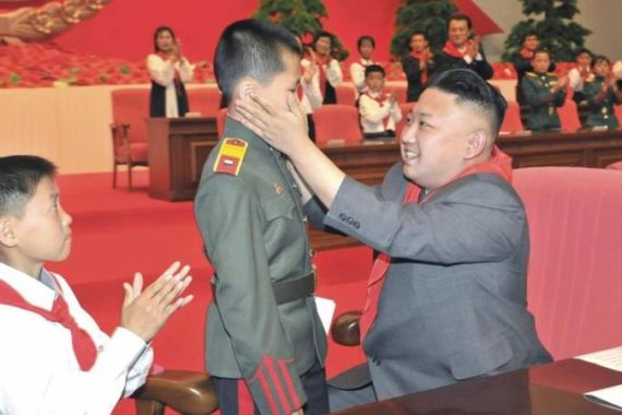 North Korean leader Kim Jong-Un greets a child during the 7th Congress of the KCU at the April 25 House of Culture in Pyongyang