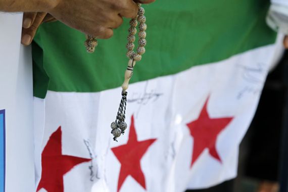 A Syrian community in Romania holds a rosary during a protest in front of the Syrian embassy in Bucharest