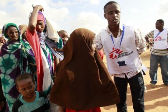 A MSF worker ushers newly arrived Somali refugees before they are administered polio vaccine at the Ifo extension refugee camp in Dadaab