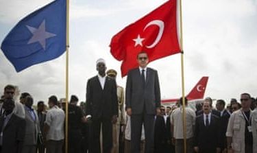 Turkey''s PM Erdogan and Somalia''s President Ahmed stand in front of their countries'' national flags as they listen to the national anthems in Mogadishu