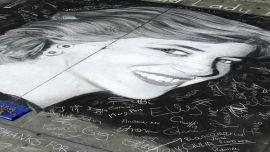 People look at a picture of Lady Diana drawn by a pavement artist in Trafalgar Square in London
