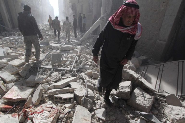 A man walks on debris, at a site hit by what activists said was a barrel bomb dropped by forces loyal to Syria''s President Bashar al-Assad, in the al-Myassar neighbourhood of Aleppo