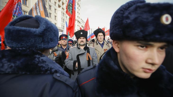 People wearing St. George''s Ribbons stand in front of police during "Anti-Maidan" rally in Moscow