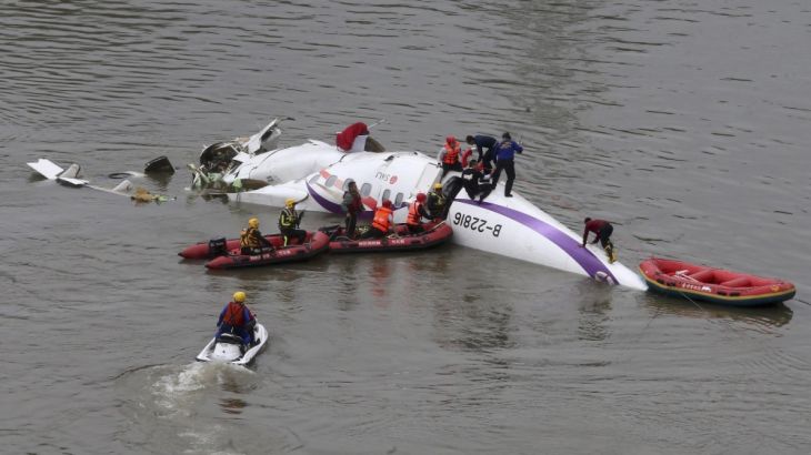 Rescuers carry out a rescue operation after a TransAsia Airways plane crash landed in a river, in New Taipei City