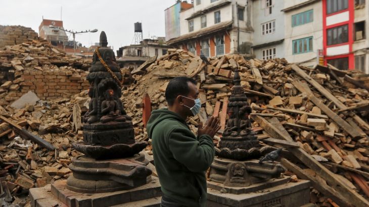 A man prays next to rubble of a temple, destroyed in Saturday''s earthquake, in Kathmandu