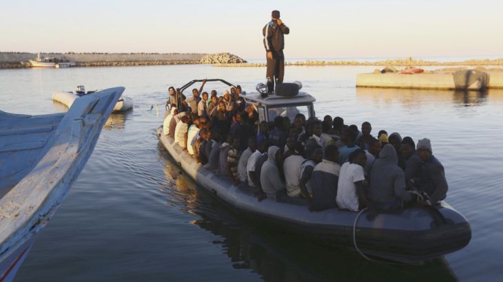African migrants are seen seated in a boat, after being rescued by the Libyan navy