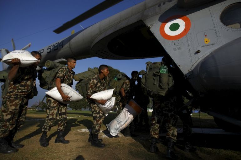 Nepalese soldiers, carrying earthquake relief aid, board a helicopter at Charikot in Dolkha district