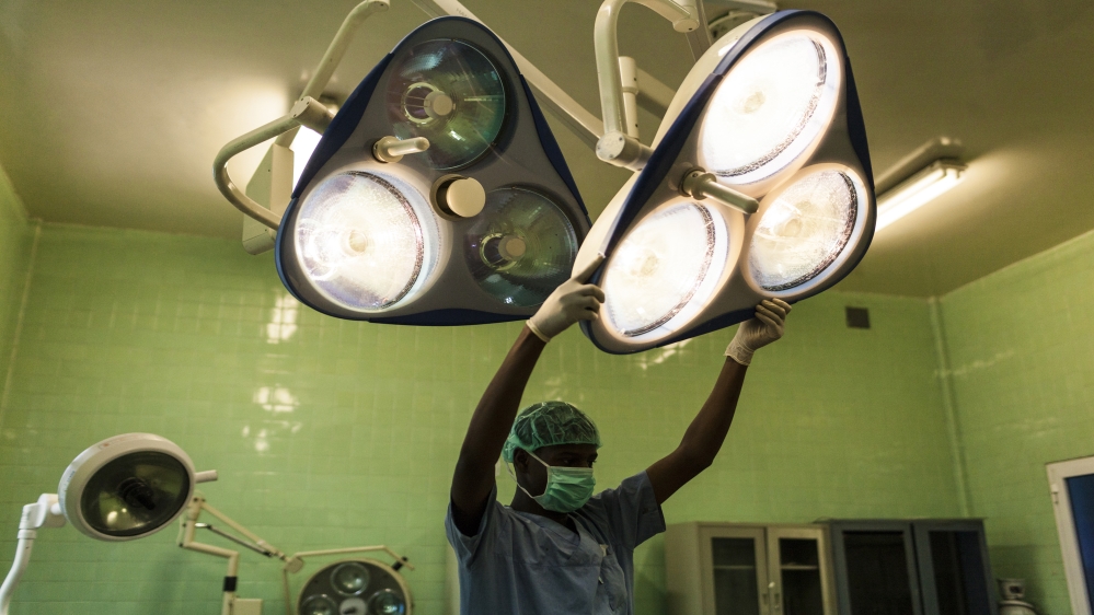 A doctor adjusts the lighting in preparation for an emergency caesarian section [Adriane Ohanesian]