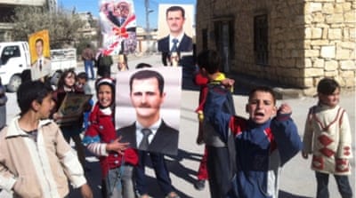 Children hold portraits of Bashar al-Assad to welcome pro-regime soldiers in Qalamoun [AFP]