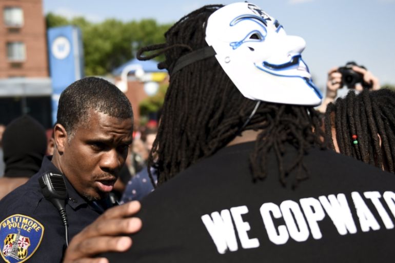 A law enforcement officer speaks to a protester at the intersection of North and Pennsylvania Avenues in Baltimore