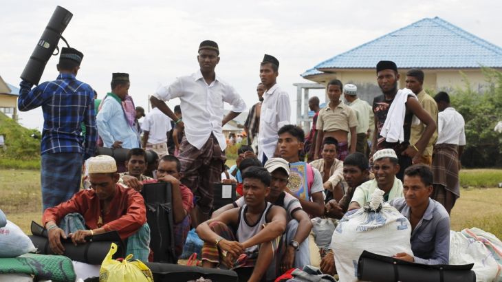Rohingya migrants, who arrived in Indonesia by boat, queue up as they move to better shelter inside a temporary compound for refugees in Kuala Cangkoi village in Lhoksukon