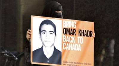 Protester holding a sign urging the Canadian government to bring Khadr back to Canada in 2009 [Getty]