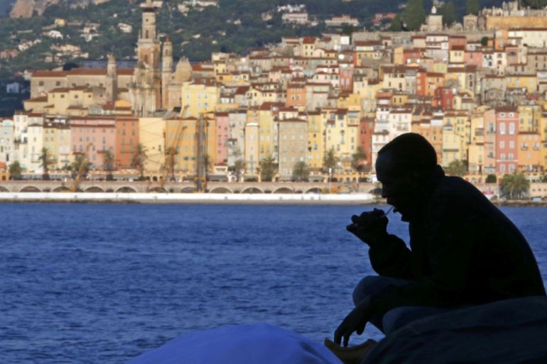 A migrant is silhouetted at the Saint Ludovic border crossing on the Mediterranean Sea