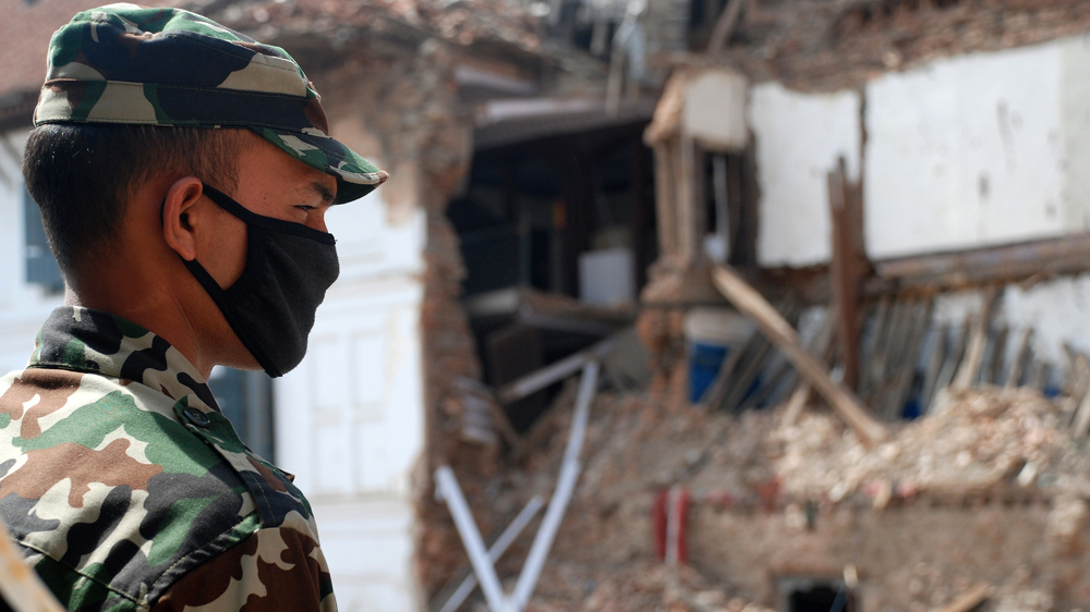 A soldier guarding an earthquake-damaged heritage site near Durbar Square [Ingrid Piper/Al Jazeera]