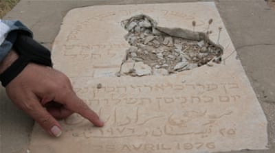 Nagi Zeidan points to an engraved slab removed from a tomb [Venetia Rainey/Al Jazeera]
