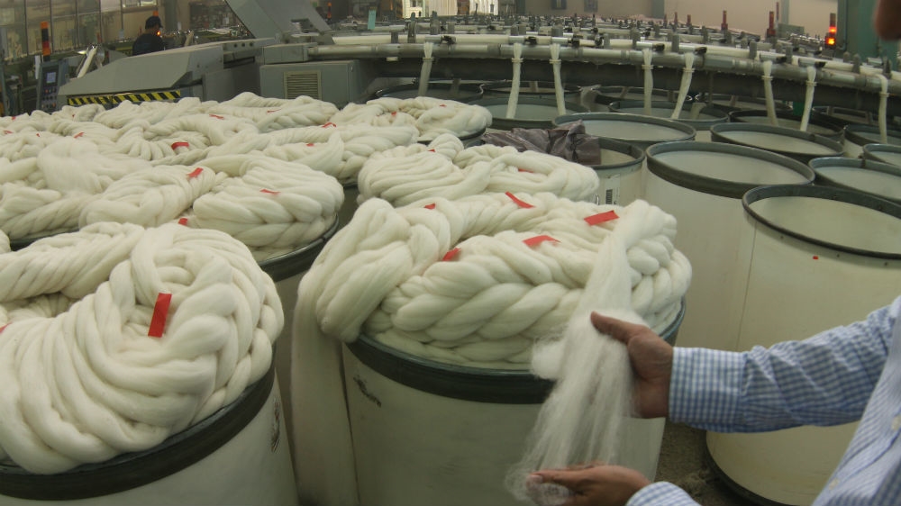 Wool is cleaned and gradually untwisted into single threads to make clothing [Alex Pashley/Al Jazeera]
