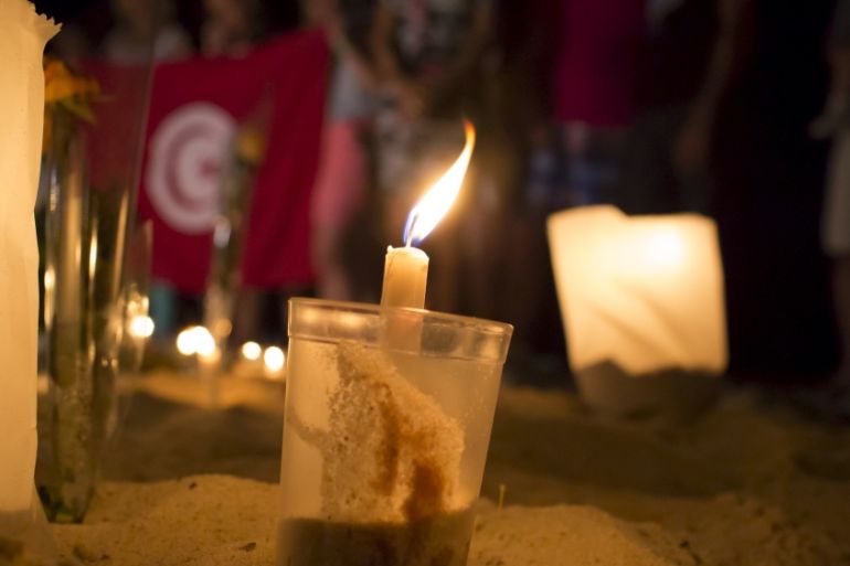 A lit candle is seen in the sand in front of the Imperial Marhaba Hotel, where a gunman carried out an attack, in Sousse, Tunisia [REUTERS]