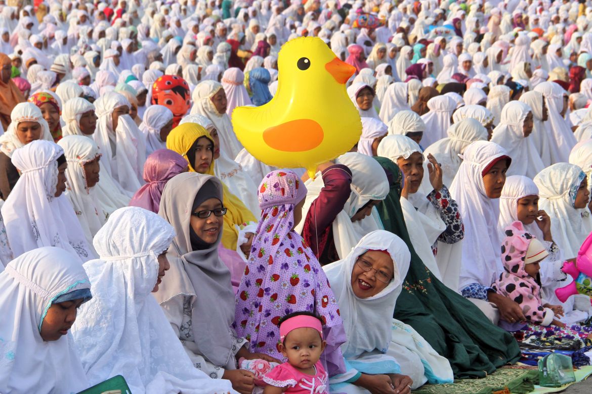 Muslim women attend an Eid al-Fitr prayer marking the end of the holy fasting month of Ramadan at Parangkusumo beach in Yogyakarta, Indonesia