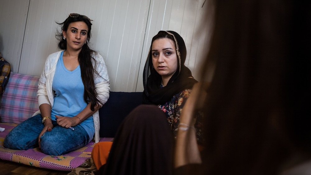 Nasreen Seedo and Roujda Yunis, team members of Wadi's female mobile units, listen to a survivor of physical and sexual abuse describe her ordeal [Andrea DiCenzo/Al Jazeera]