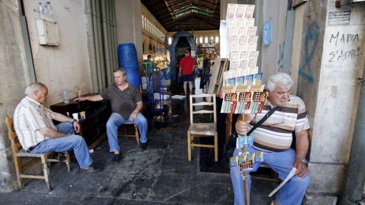 A lottery ticket vendor waits for customers in a local market in central Athens