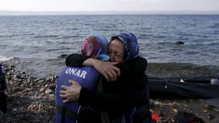 Two Afghan migrant women hug, moments after they arrived on a dinghy on the island of Lesbos
