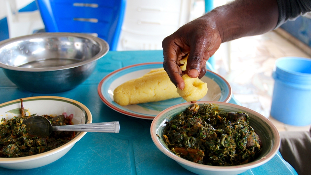 Her customers' favourite dishes are afang and edikang ikong (shown here) soups eaten with starchy dough [Femke van Zeijil/Al Jazeera]