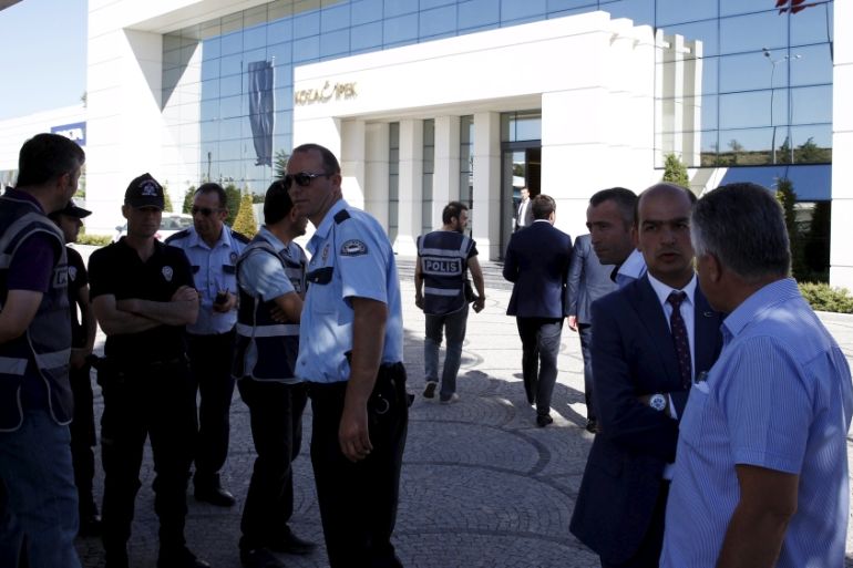Police officers guard the entrance as they raid an office of Koza Ipek Group in Ankara, Turkey