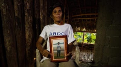 Emerita Pernicita shows a picture of her son, Nel, who died in an underground pit [Mark Z Saludes for Human Rights Watch]