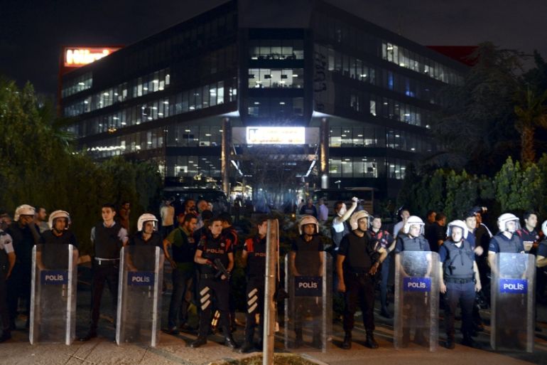 Turkish riot police stand guard in front of the headquarters of the Hurriyet daily newspaper in Istanbul, Turkey