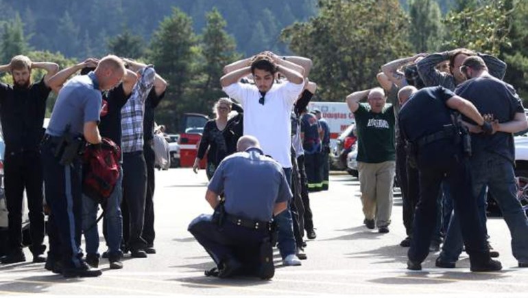 Police officers inspect bags as students and staff are evacuated from campus following a shooting incident at Umpqua Community College in Roseburg Oregon