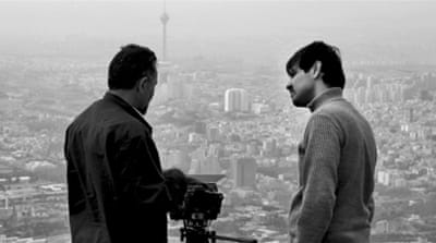 Keywan Karimi talks to a cameraman while working on a scene from the movie 'Writing on the City', overlooking the city of Tehran [AP]