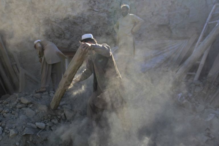 Men clear rubble from their house after an earthquake, in Behsud district of Jalalabad province, Afghanistan