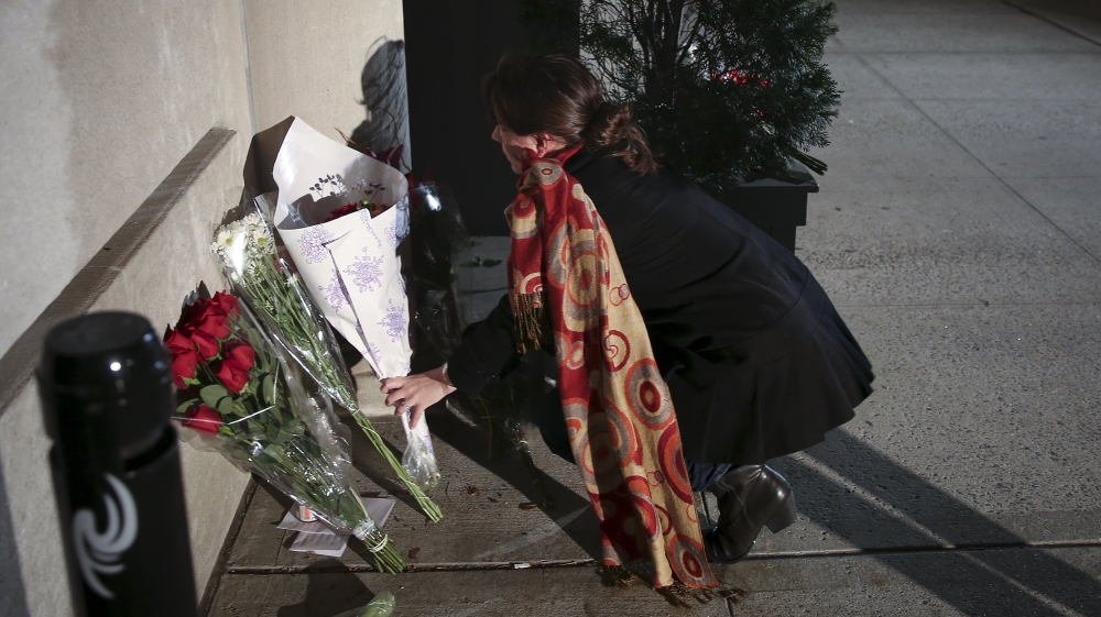 A woman leaves flowers at a makeshift memorial outside the consulate of France in New York [Reuters]