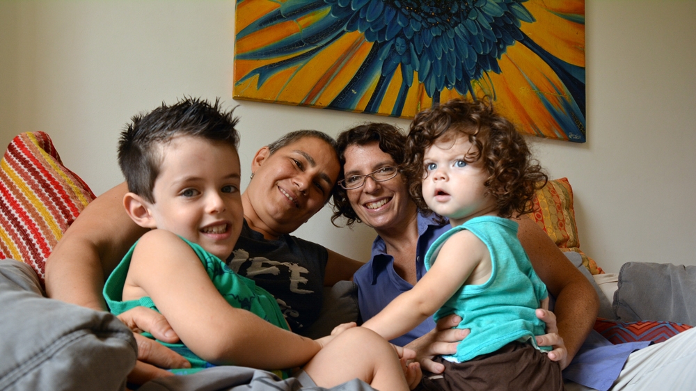 Ana and Adriana at home with their children [Priscilla Moraes/Al Jazeera]