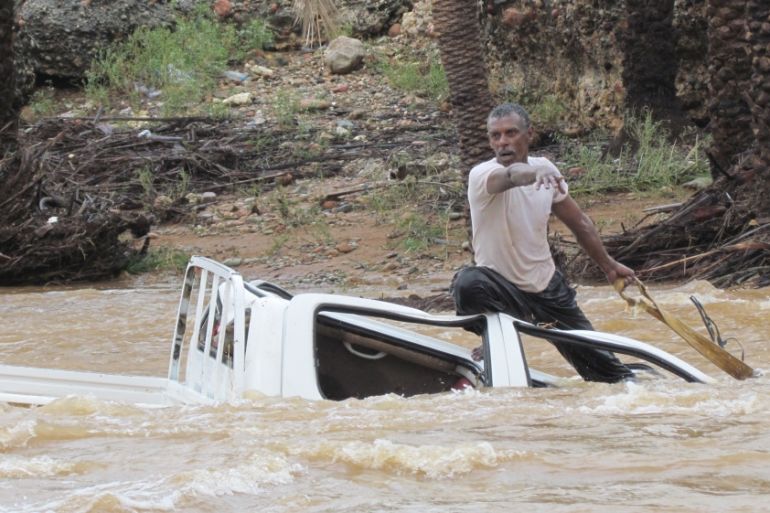 A man gestures as he tries to save a vehicle swept away by flood waters in Yemen''s island of Socotra