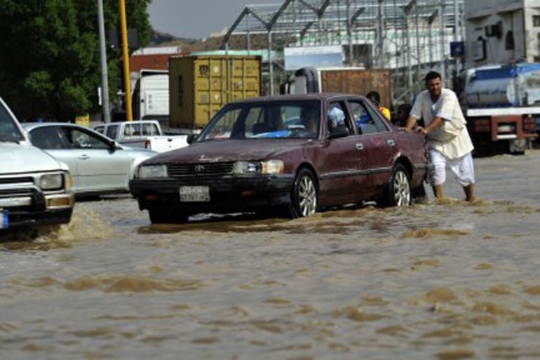 Pushing a car in floods in Jeddah, Saudi Arabia