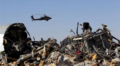 An Egyptian military helicopter flies over debris from a Russian airliner which crashed at the Hassana area in Arish city, north Egypt [Reuters]