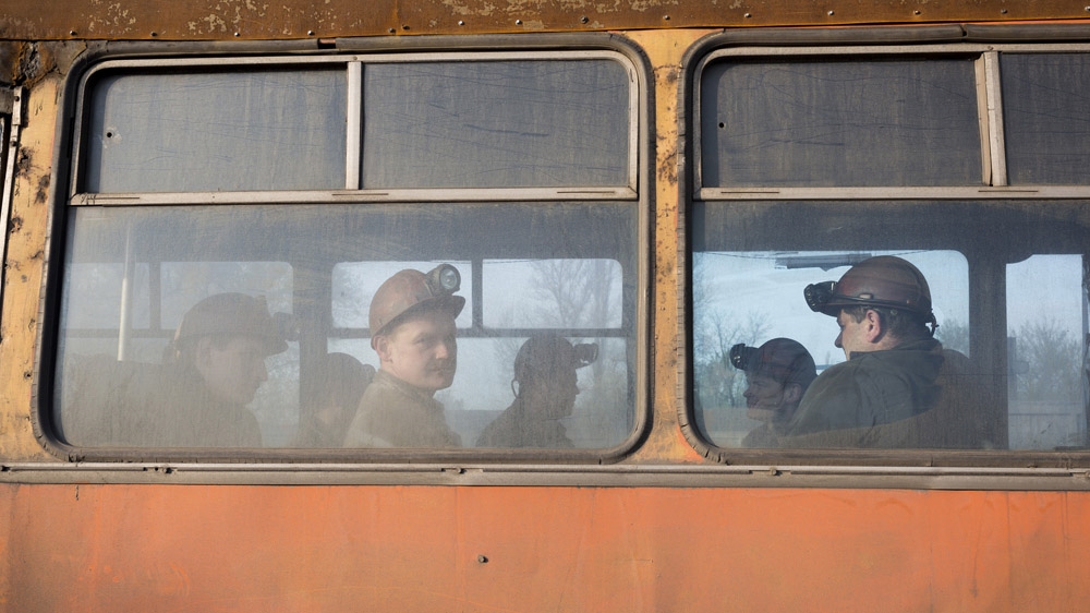 Miners on the bus to go to work in the early hours of the morning in Makeevka, a mining town on the outskirts of Donetsk. [Janos Chiala and Tali Mayer/Al Jazeera]  