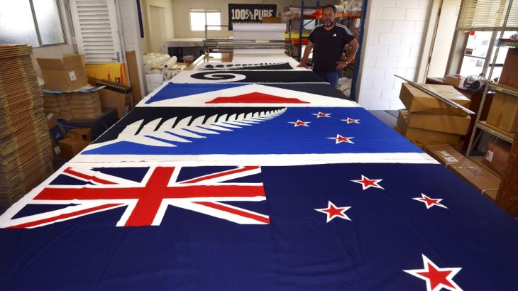Factory worker Dion Williams looks at new designs of the national flag of New Zealand laid out on a table at a factory in Auckland, New Zealand