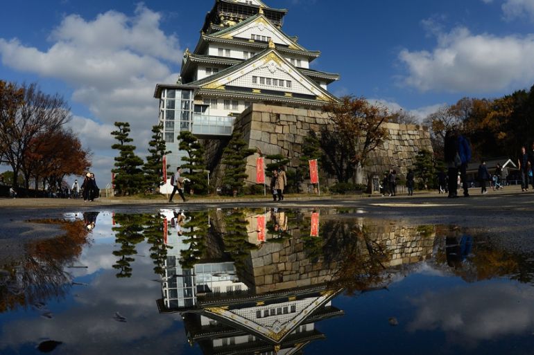Osaka Castle reflected in a puddle, Japan