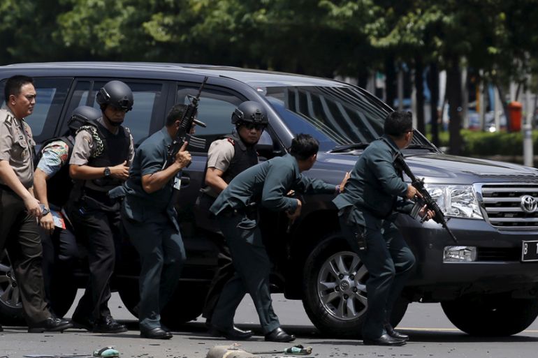 Police officers react near the site of a blast in Jakarta,