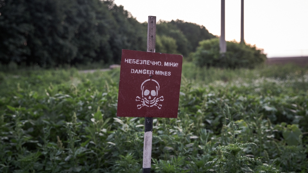  A 'Danger - mines' warning sign posted in a field near a military checkpoint on one the roads around Donetsk Oblast [Ioana Moldovan/Al Jazeera]