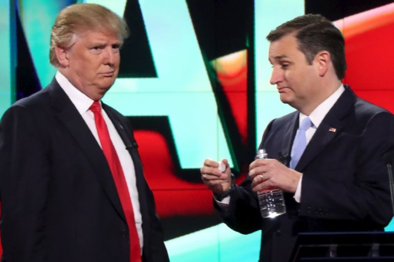 Republican U.S. presidential candidate Trump talks with rival Cruz during a break at the candidates debate in Miami