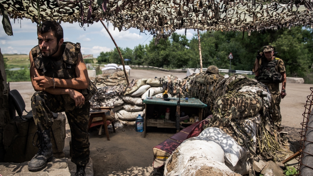 Ukrainian soldiers mending the checkpoint in Donetsk Oblast [Ioana Moldovan/Al Jazeera]