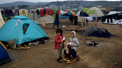 Syrian children play outside a tent at the Greek-Macedonian border station of Idomeni, Greece [Al Jazeera]