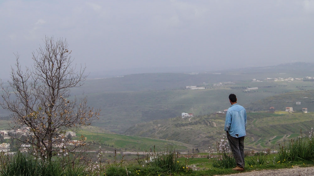 Asim looks at the hills of his hometown Talkalakh in Syria [Natalia Ojewska/Al Jazeera]