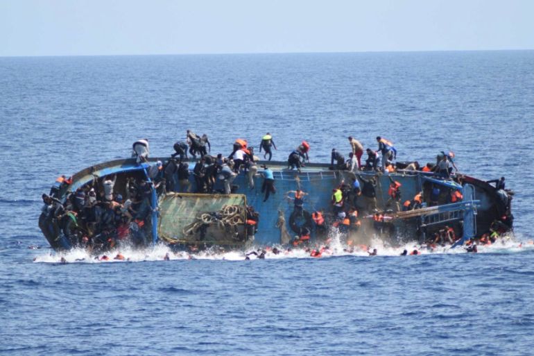 DO NOT USE - Migrants are seen on a capsizing boat before a rescue operation by Italian navy ships "Bettica" and "Bergamini" (unseen) off the coast of Libya