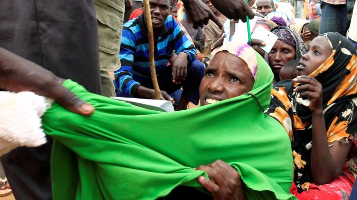 A newly arrived Somali refugee is forced out of the queue outside a reception centre in the Ifo 2 refugee camp in Dadaab, near the Kenya-Somalia border, in Garissa County
